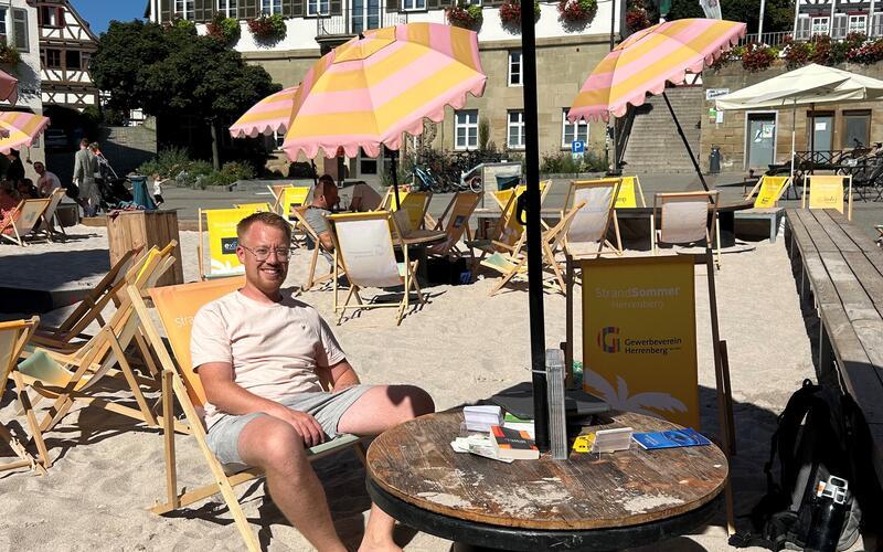 Sven Faix an seinem vorübergehend neuen Arbeitsplatz, auf einem Liegestuhl im Sand. GB-Foto: Mohr
