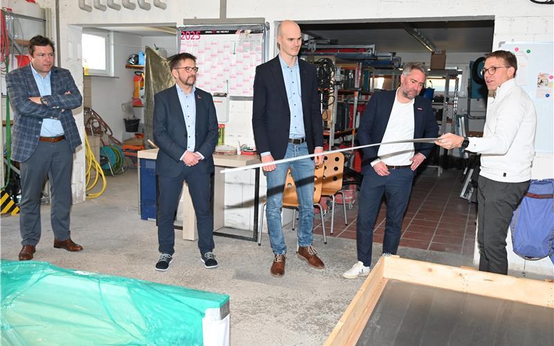 Titus Wolkober demonstriert an einem Reststück die Biegsamkeit einer Großfliese. Darüber staunen (von links): Gärtringens Bürgermeister Thomas Riesch, Kreishandwerksmeister Hartmut Nietsch, der Landtagsabgeordnete Peter Seimer und Christoph Gräter von der Handwerkskammer Region Stuttgart. GB-Foto: Reichert