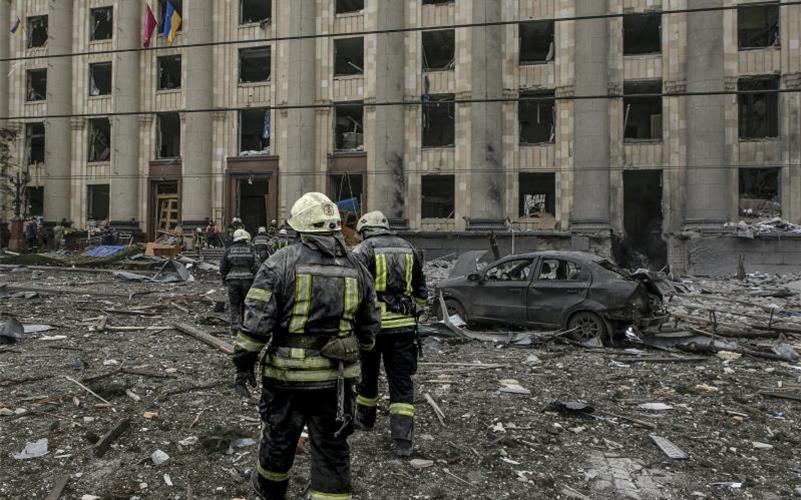 Ukrainische Rettungskräfte arbeiten vor dem beschädigten Rathausgebäude in Charkiw nach dem russischen Beschuss. Foto: Pavel Dorogoy/AP/dpa