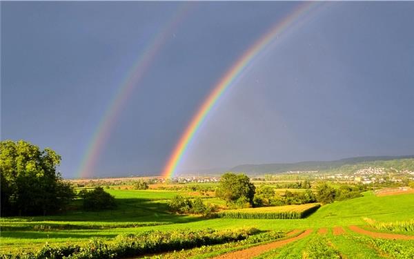 Unter dem Regenbogen leuchtet die Landschaft