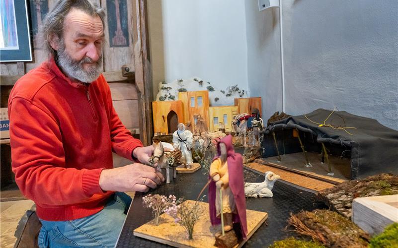 Vorsichtig drapiert Achim Reutter die Krippenszene im Altarraum der Michaelskirche in Entringen. Bis auf Maria, Josef und das Jesuskind sind alle Figuren und Tiere neu und von dem Mesner aus Lindenholz handgeschnitzt. Für die Gewänder und Decken sowie das Beduinenzelt verarbeitete Ehefrau Susanne Reutter Stoffreste in aufwendiger Nähhandarbeit.GB-Fotos: Vecsey