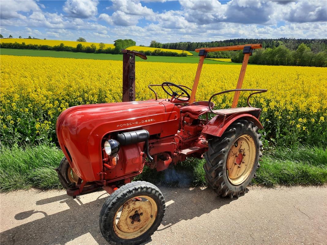 Was für ein farblicher Kontrast: Knallroter, 60 Jahre alter Porsche-Traktor steh...