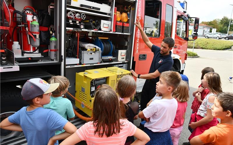 Was passt alles in ein Feuerwehrauto? Die jungen Besucher hören interessiert zuGB-Foto: Holom