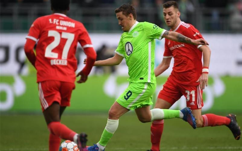 Wolfsburgs Max Kruse (M) versucht sich gegen Unions Sheraldo Becker und Robin Knoche durchzusetzen. Foto: Swen Pförtner/dpa
