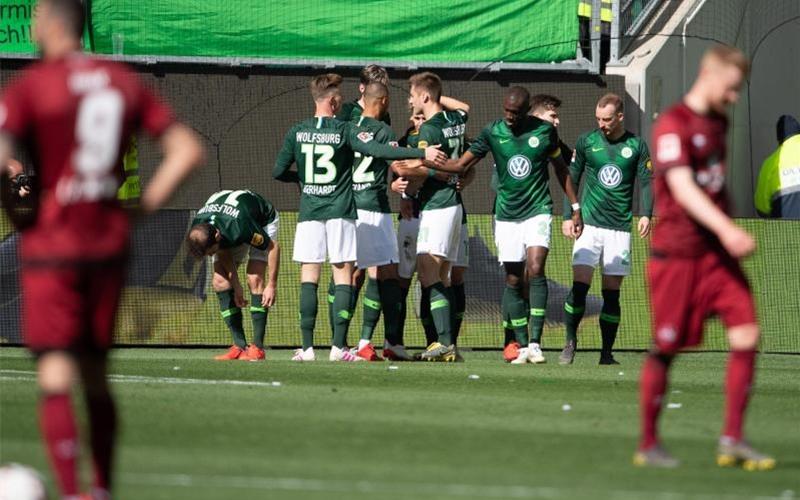 Wolfsburgs Spieler jubeln nach dem 1:0, die Nürnberger lassen im Vordergrund die Köpfe hängen. Foto: Swen Pförtner