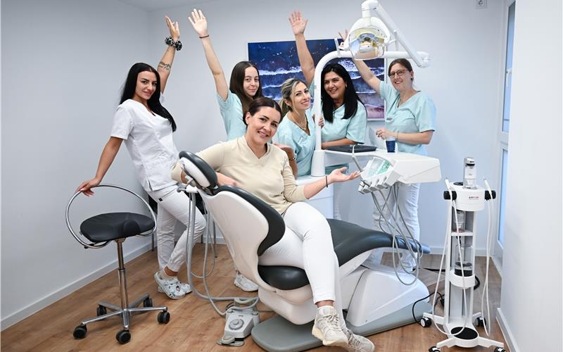 Zahnärztin mit Sinn für Show und Humor: Christina Fotiadou-Markianidou sitzt in einem Behandlungsstuhl in der Praxis in der Schillerstraße in Herrenberg, umgeben von fünf Helferinnen, die auch in den Instagram-Reels mitwirken.GB-Foto: Bernd Weißbrod (dpa)