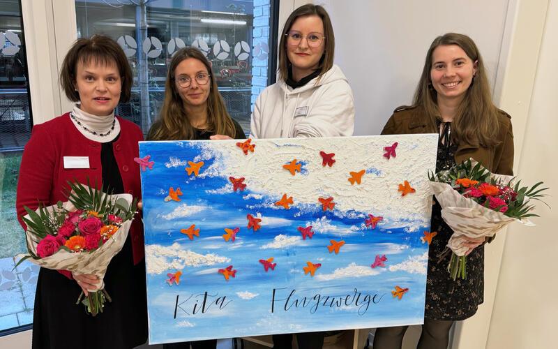 Zum einjährigen Bestehen der Kita Flugzwerge überreicht die Kita-Leitung der KVSW-Projektleitung ein mit Eltern, Kindern und Fachkräften gestaltetes Jubiläums-Gemälde (von links): Kerstin Franz (KVSW-Projektleitung), Laura Mauthe (stellvertretende Kita-Leitung), Lynn Kutter (Leiterin), Anne-Lena Stierle (KVSW-Projektleitung). GB-Foto