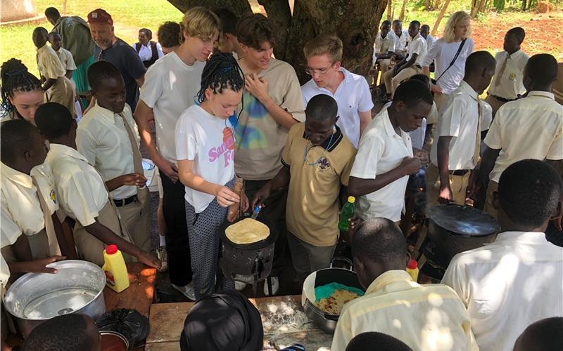 Zwölf Schüler und Lehrer vom AGH beim Kochen mit ihren ugandischen Gastgebern. GB-Foto: gb